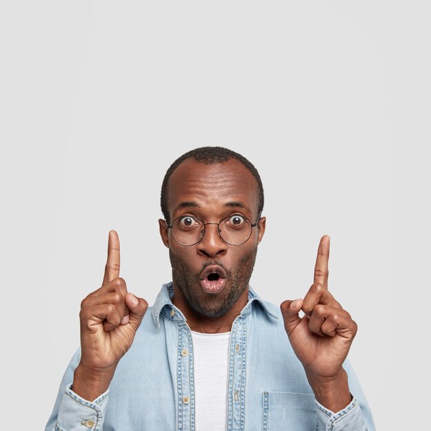 Coup vertical de jeune homme afro-américain étonné avec une expression stupéfaite