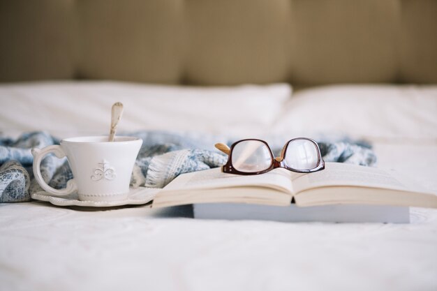 Coupe avec boisson près du livre et des lunettes