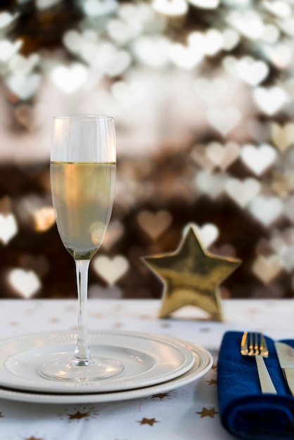 Coupe de champagne sur assiette effet bokeh en forme de coeur