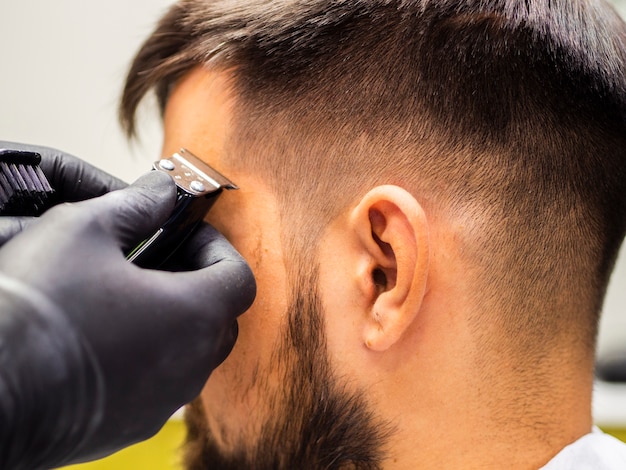 Photo gratuite coupe de cheveux en gros plan et gants noirs