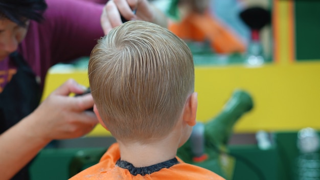 Coupe De Cheveux D Un Petit Garcon Dans Un Salon De Coiffure Pour Enfants Photo Premium Coupe De Cheveux D Un Petit Garcon Dans Un Salon De Coiffure Pour Enfants Photo Premium