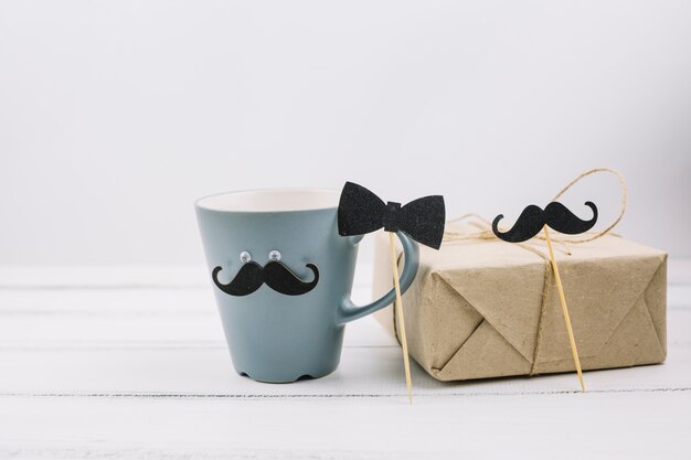 Coupe avec moustache ornementale près de la boîte et noeud papillon sur la baguette