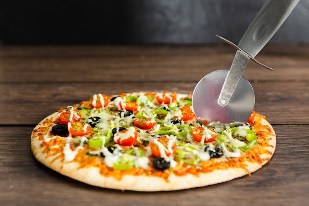 Photo gratuite coupe de pizza sur une surface en bois