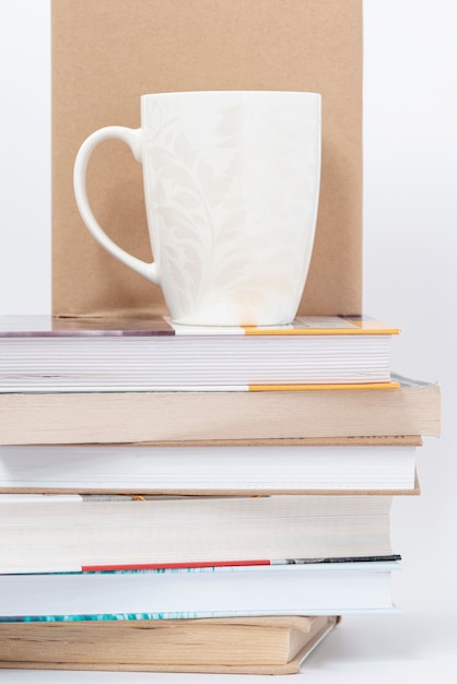 Photo gratuite coupe placée sur une pile de livres