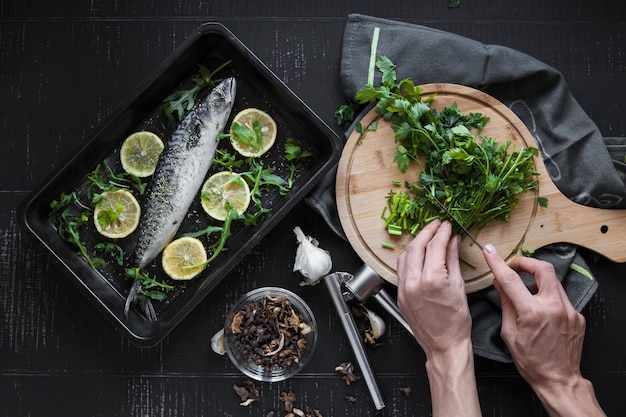 Photo gratuite couper les mains couper le persil pour le poisson