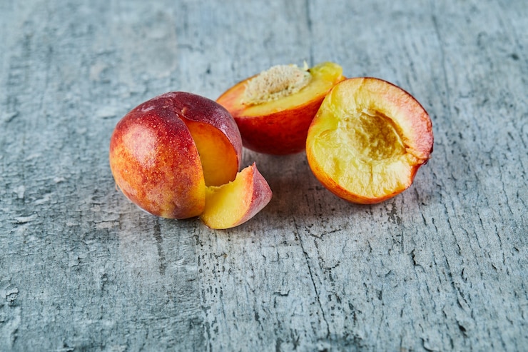 Photo gratuit couper les nectarines mûres sur la surface du marbre