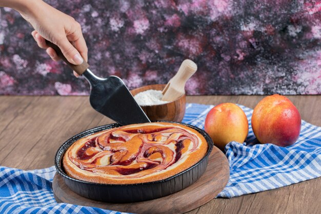 Couper une tranche de tarte au sirop de chocolat sur une planche de bois.