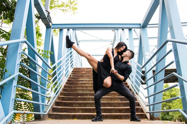 Couple affectueux dansant sur le pont