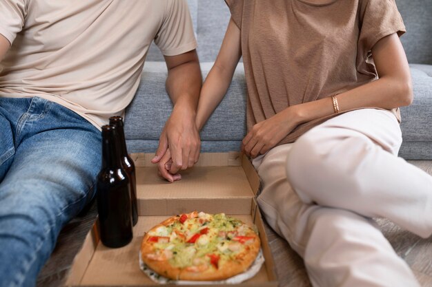 Photo gratuite couple affectueux à la maison ayant de la pizza et de la bière