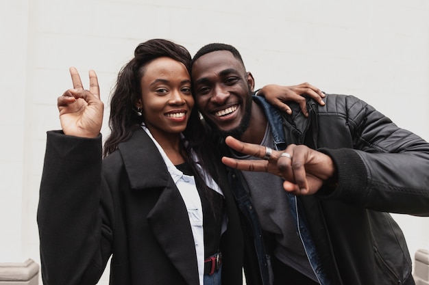 Photo gratuite couple afro-américain montrant le signe de la paix