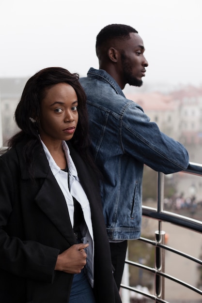 Couple afro-américain sérieux posant sur balcon