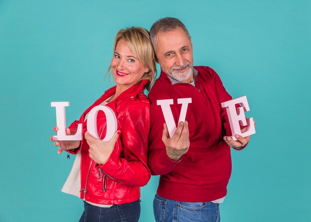 Couple âgé montrant une inscription d&#39;amour