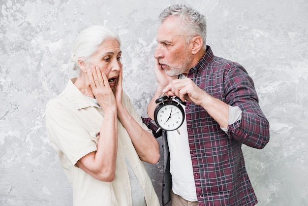 Photo gratuite couple aîné, tenue horloge