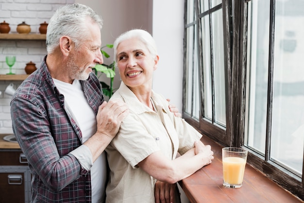 Couple d&#39;aînés regardant par la fenêtre