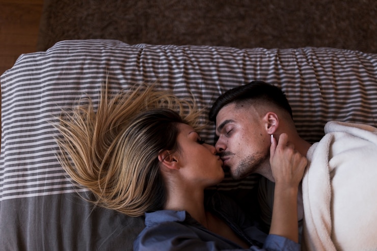 Photo gratuit couple allongé sur le lit en s&#39;embrassant