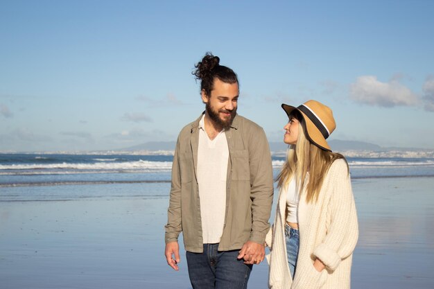 Couple d'amoureux marchant près de l'eau en été