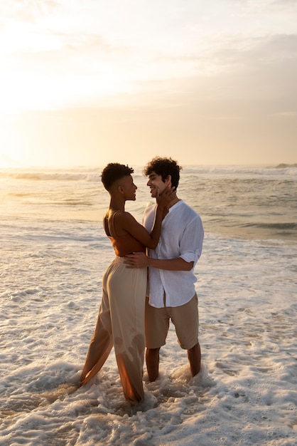 Photo gratuite couple d'amoureux montrant de l'affection sur la plage près de l'océan