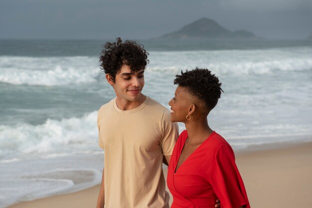 Couple d'amoureux montrant de l'affection sur la plage près de l'océan