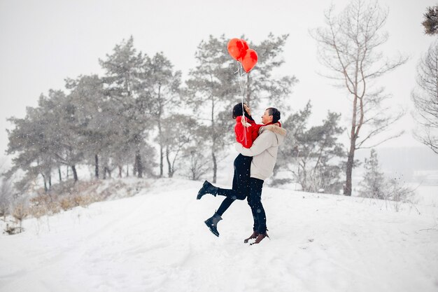 Couple d'amoureux à pied dans un parc d'hiver