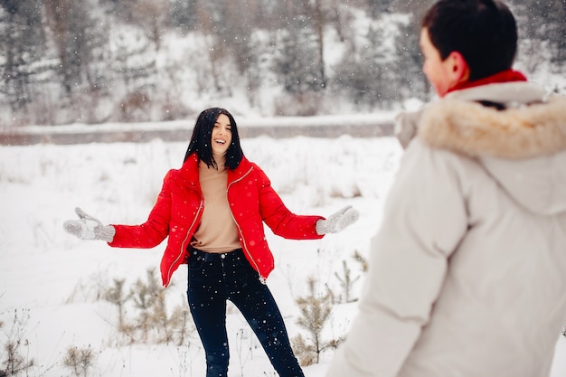 Couple d'amoureux à pied dans un parc d'hiver