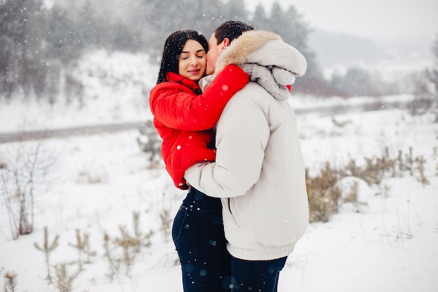 Couple d'amoureux à pied dans un parc d'hiver