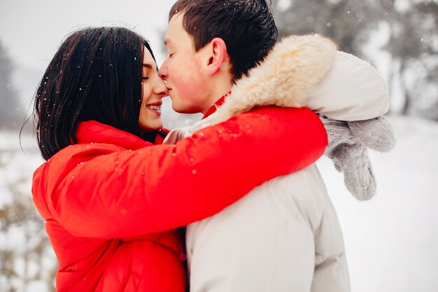 Couple d'amoureux à pied dans un parc d'hiver