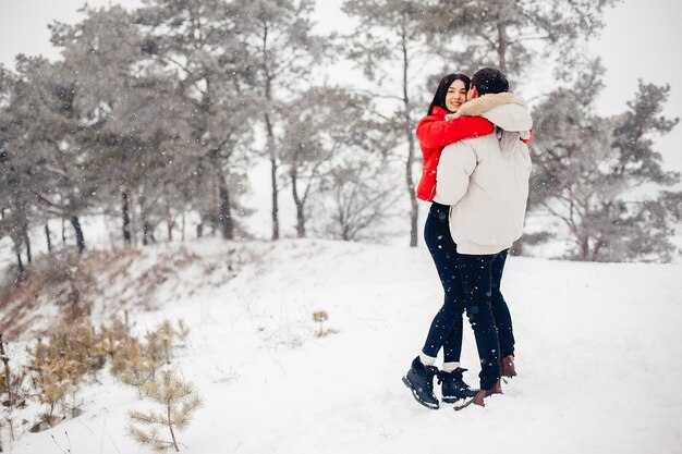 Couple d'amoureux à pied dans un parc d'hiver