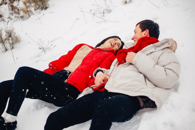 Couple d'amoureux à pied dans un parc d'hiver