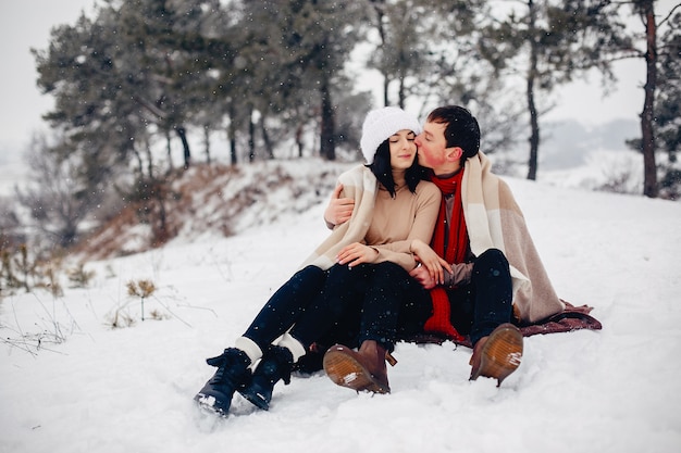 Couple d'amoureux à pied dans un parc d'hiver