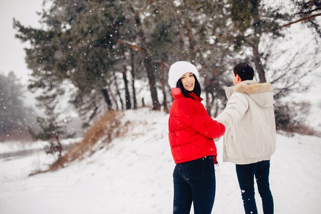 Couple d'amoureux à pied dans un parc d'hiver