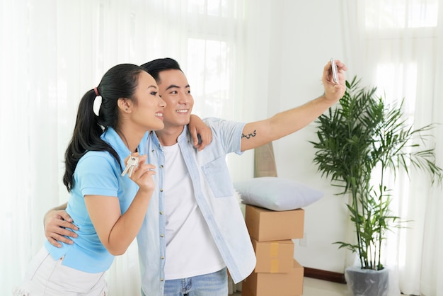 Couple d'amoureux prenant selfie dans une nouvelle maison