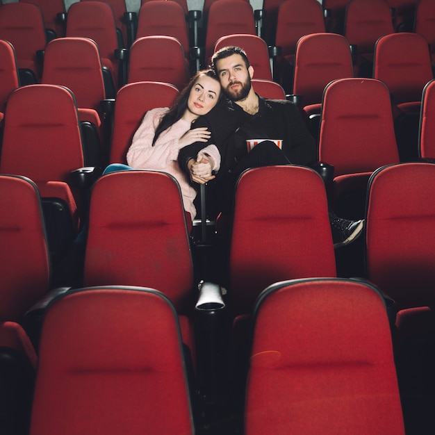 Photo gratuite couple d'amoureux en regardant un film au cinéma