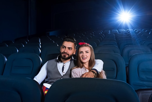 Couple d'amoureux regardant un film dans le cinéma vide
