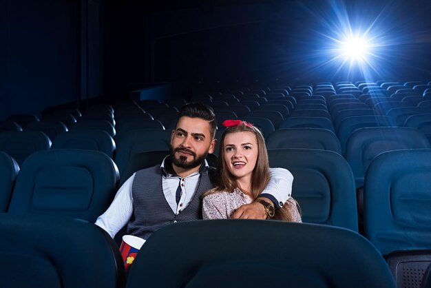 Couple d'amoureux regardant un film dans le cinéma vide