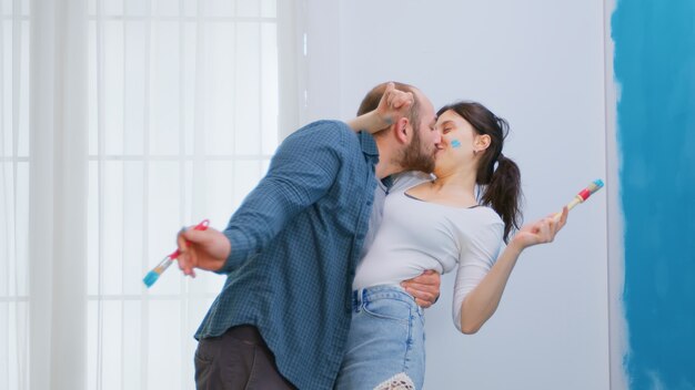 Couple d'amoureux rénovant l'intérieur de la maison et se peignant. Redécoration d'appartements et construction de maisons tout en rénovant et en améliorant. Réparation et décoration.