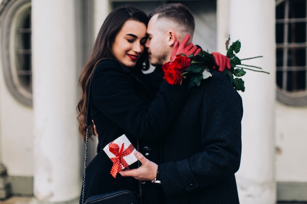 Couple d&#39;amoureux avec des roses embrassant dans la rue