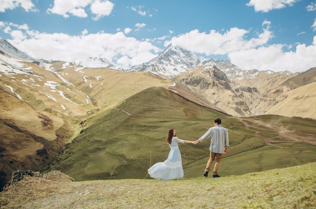 couple d&#39;amoureux se promène dans le fond des hautes montagnes avec des glaciers au sommet