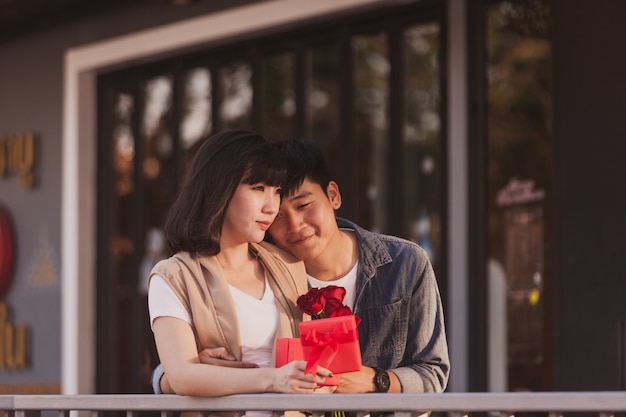 Couple amoureux tenant un cadeau rouge