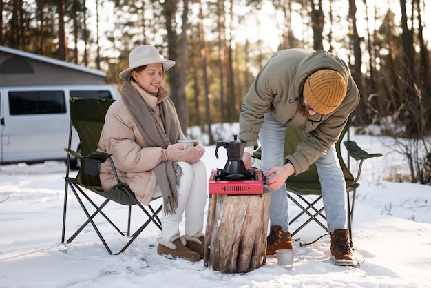 Photo gratuite couple appréciant leur camp d'hiver