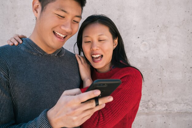 Couple asiatique en regardant le téléphone mobile.