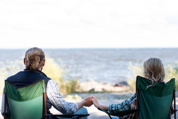 Couple assis sur des chaises et main dans la main