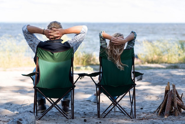 Photo gratuite couple assis sur des chaises par derrière