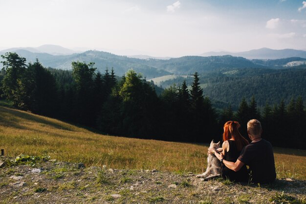 Couple assis sur un champ vert regardant la nature