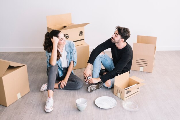 Couple assis dans un nouvel appartement