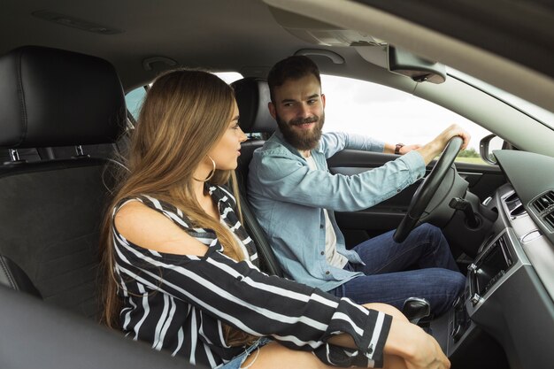 Couple assis dans la voiture se regardant