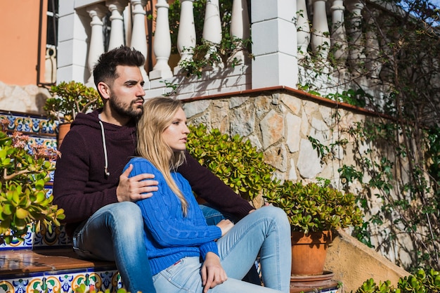 Couple assis sur les escaliers en plein air mignon