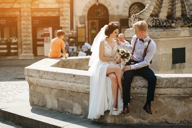 Couple assis sur une fontaine