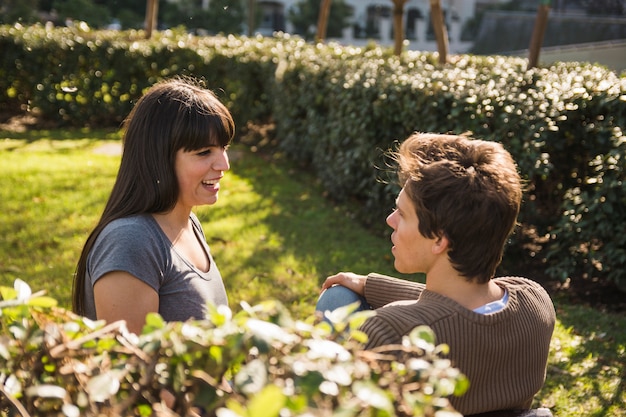 Photo gratuite couple assis sur l'herbe dans le parc