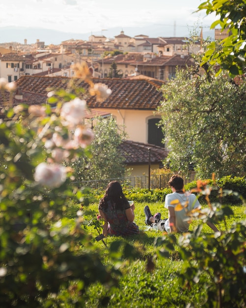 Photo gratuite couple assis sur l'herbe avec florence dans le