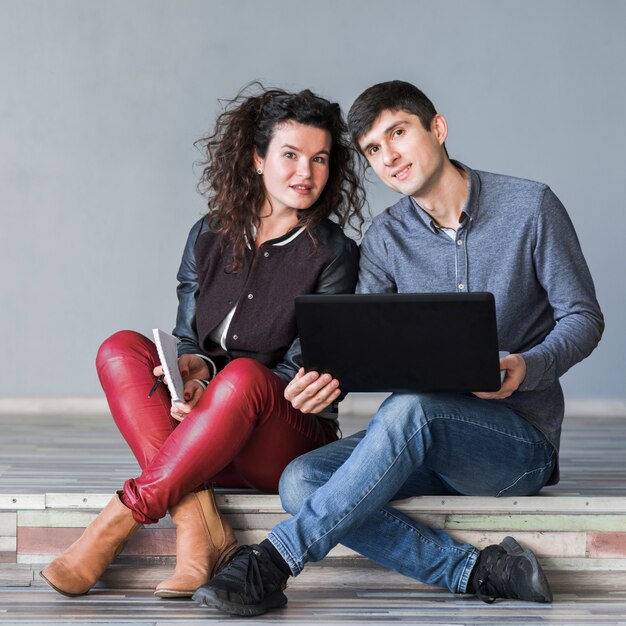 Couple assis avec ordinateur portable